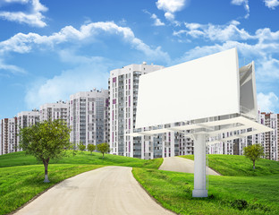 Tall buildings, green hills and road with large billboard