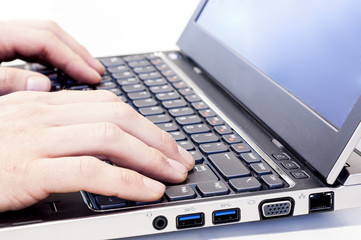 Hands typing on laptop