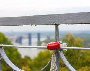 Red Lock in heart shape on bridge