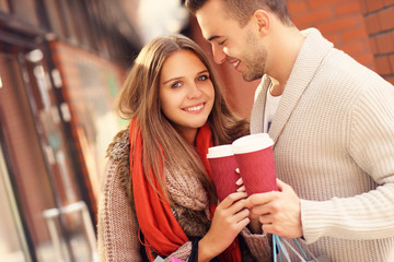 Joyful couple with coffee shopping in the mall