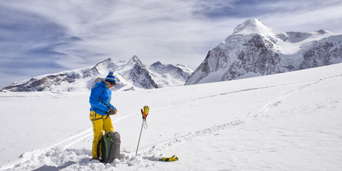Lonely man with ski in alpine landscape - 73305853