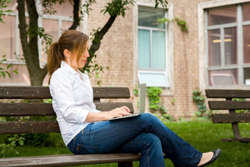 woman in park with her computer