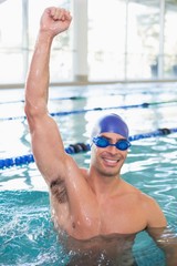 Fit swimmer cheering in pool at leisure center