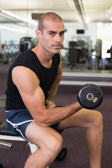 Fototapeta na wymiar Man exercising with dumbbell in gym