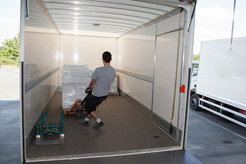 Déchargement de marchandises avec une palette dans la remorque d'un camion