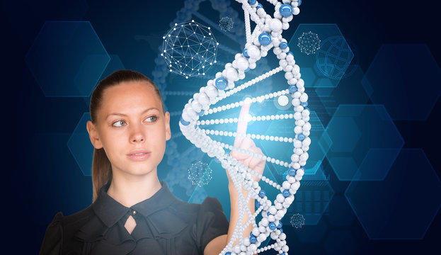 Beautiful businesswoman in dress presses finger on model of DNA