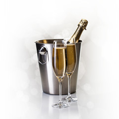Champagne bottle in bucket with glasses of champagne