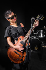 Fototapeta premium Young woman playing guitar during the concert