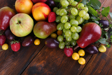 Different berries and fruits on wooden table close-up