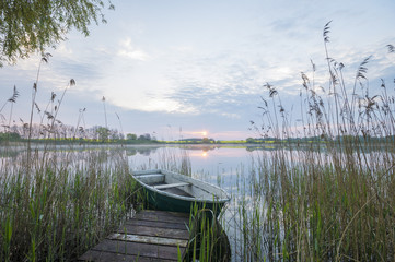 Łódka przy pomoście nad zamglonym jeziorem © Mike Mareen
