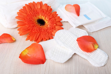 Fototapeta na wymiar Sanitary pads, orange flower and rose petals
