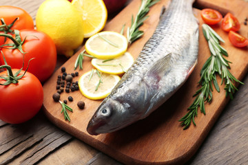 Fresh raw fish and food ingredients on table