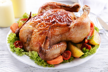 Delicious baked chicken on plate on table on light background
