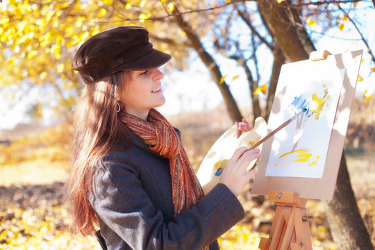 The girl draws on nature autumn