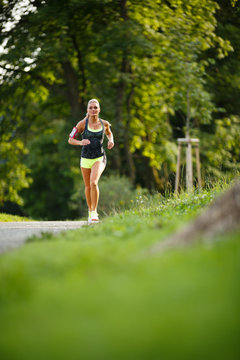 Young lady running. Woman runner running through thepark