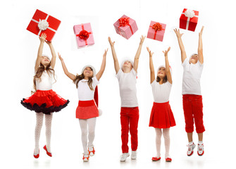 Group of happy kids in Christmas hat catching gift boxes