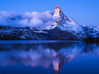 Blue hour just before sunrise. Mirror reflection of Matterhorn i