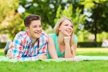 smiling couple lying on blanket in park