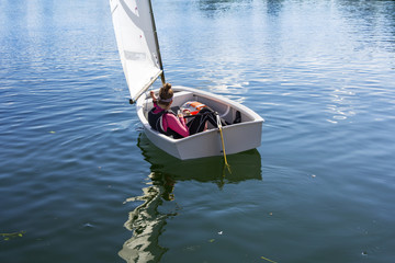 Young Girl sails on the lake on a beautiful sunny day
