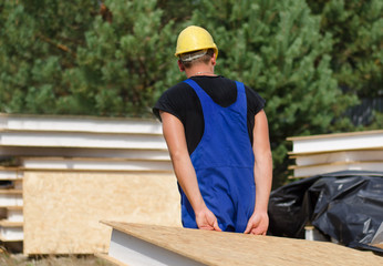 Builder carrying an insulated wall panel
