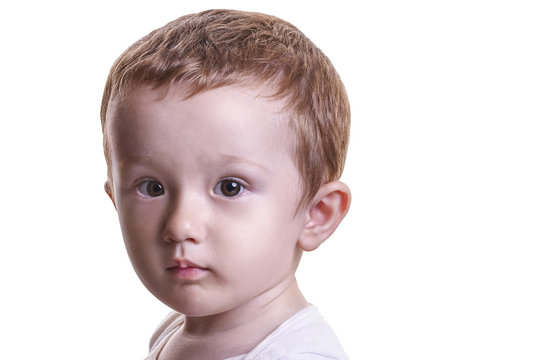Studio closeup portrait of little baby boy with serious face loo