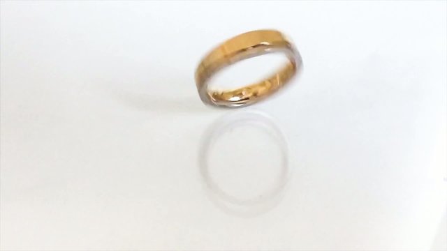 wedding ring, spinning on a white background in slow motion.