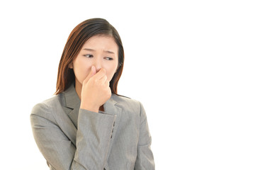 鼻をおさえる女性