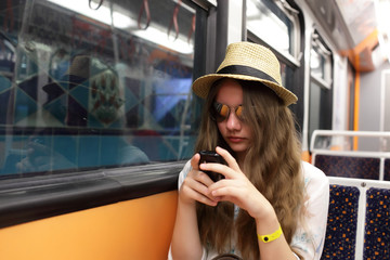 Girl with phone in subway train