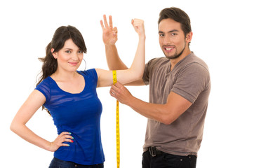handsome man holding measuring tape around thin young girl