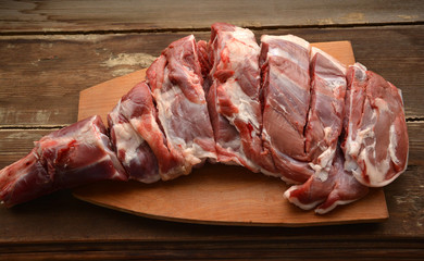 Raw lamb leg on a wooden table