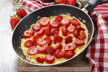 Strawberry omelette on frying pan
