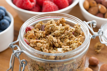 glass jar with homemade granola and fresh berries, close-up