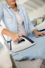 Fototapeta premium Closeup of woman ironing clothes on ironing board