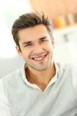 Portrait of smiling casual guy sitting in sofa