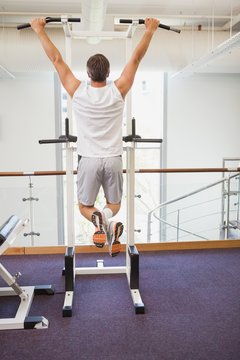 Fit Man Doing Pull Ups In Fitness Studio