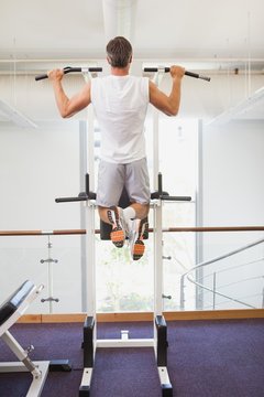 Fit Man Doing Pull Ups In Fitness Studio