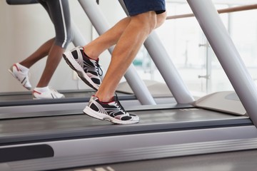 Fototapeta na wymiar Fit people running on treadmills