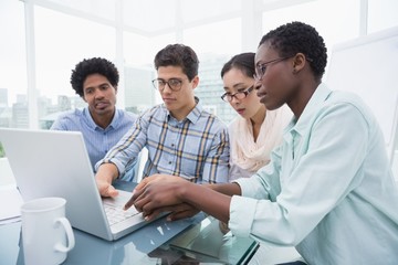 Casual business team having a meeting using laptop