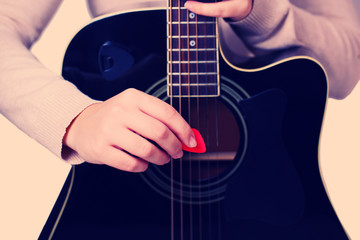 Acoustic guitar in female hands, close-up