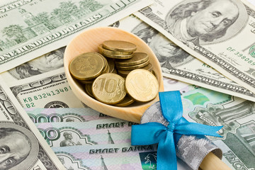 Wooden spoon with coins on a background of money