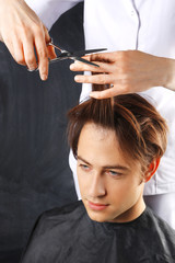 Fryzjerka podcina włosy młodemu chłopakowi