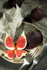 fresh figs on a ceramic plate and silver cutlery