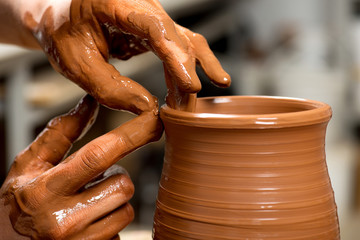 hands of a potter, creating an earthen jar