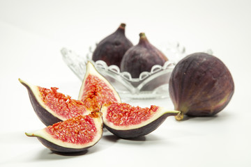 fresh figs with glass bowl, fork and knife isolated on white bac