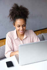 Happy young business woman working on laptop