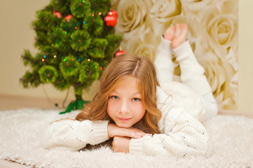 Girl lying on the carpet, looking at the camera and smiling