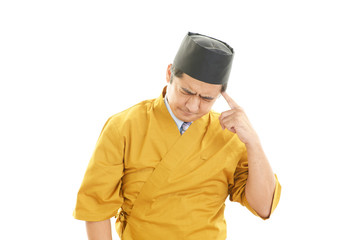 疲れた表情の寿司職人