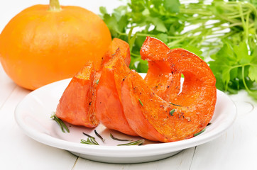 Slices of roasted pumpkin on white plate,