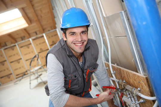 Plumber Working In Home Being Renovated