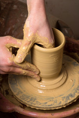 hands of a potter, creating an earthen jar